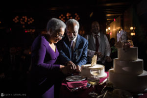 A man and woman cutting a cake at a wedding party held at 501 Union.