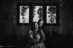 A bride and groom embracing in front of a window during their wedding at 501 Union.