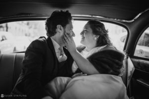 A Manhattan bride and groom sharing a passionate kiss in the back seat of a car after their intimate Private Club Wedding.