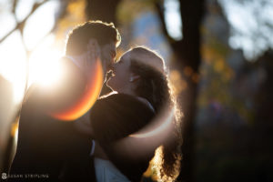A wedding couple kissing in the sunlight at a private club in Manhattan.
