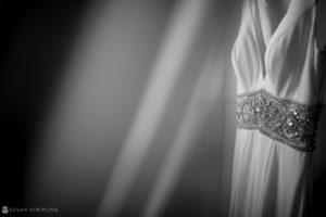 A black and white photo of a wedding dress hanging at Quantum Leap Winery.