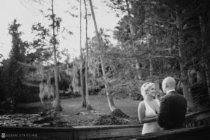 A wedding couple standing on a bridge in the woods at Quantum Leap Winery.
