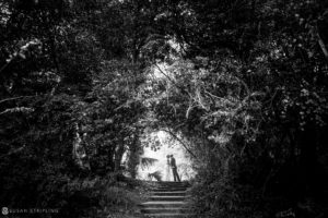A black and white photo of a wedding couple in the woods at Quantum Leap Winery.