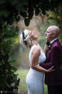 A wedding couple hugging in the woods at Quantum Leap Winery.