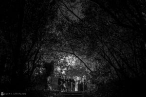 A stunning black and white photo capturing a breathtaking wedding party amidst the enchanting woods of Quantum Leap Winery.