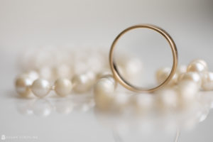 A wedding ring sits on top of pearls at the Alfond Inn.