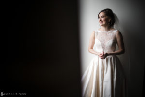 A bride in a wedding dress standing in the elegant and romantic setting of the Alfond Inn.