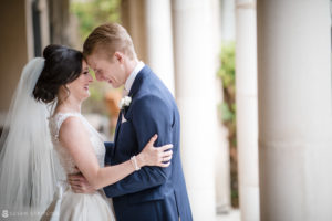 A bride and groom embrace in front of an Alfond Inn archway during their wedding celebration.