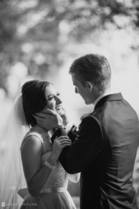 A black and white wedding photo featuring a bride and groom hugging each other at the Alfond Inn.