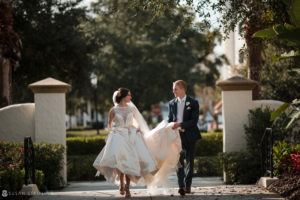 A bride and groom walking down a path at their wedding in the enchanting Alfond Inn.