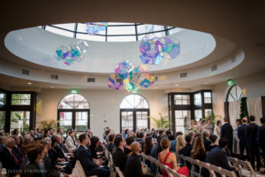 A wedding ceremony at the Alfond Inn, a room with a circular ceiling.
