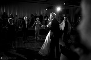 A bride and groom elegantly dance at their wedding reception held at the Alfond Inn.