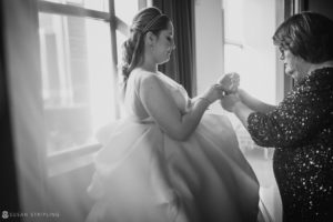 A woman is helping her daughter put on her wedding ring at a Winter wedding.