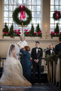 A winter wedding ceremony in a church with a bride and groom.