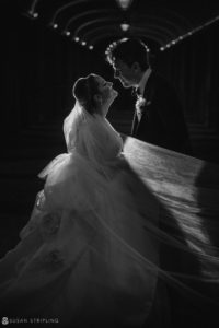 A black and white photo of a bride and groom in a tunnel at their elegant Winter wedding at Front and Palmer.