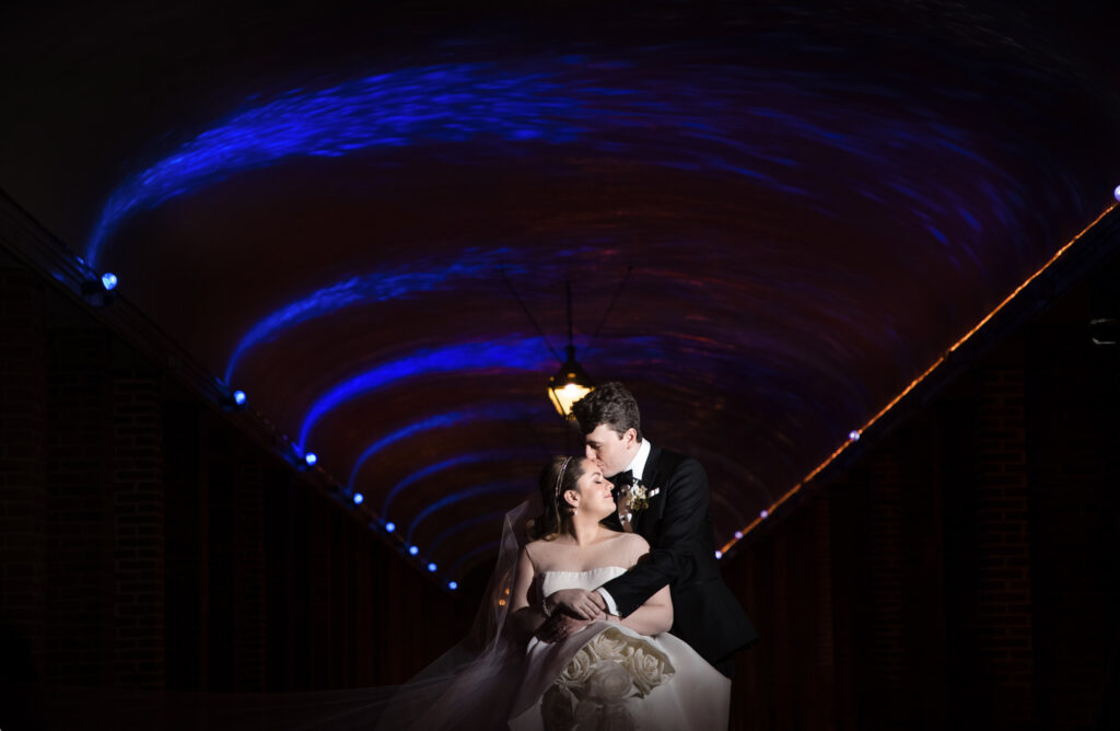 A Winter Wedding couple standing under a blue light tunnel at Front and Palmer.
