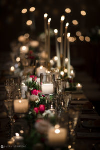 At the Front and Palmer venue, a table is elegantly set with candles and flowers for a Winter Wedding.
