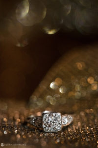 A diamond engagement ring shining on a gold background, perfect for a wedding at Philly's Union League.