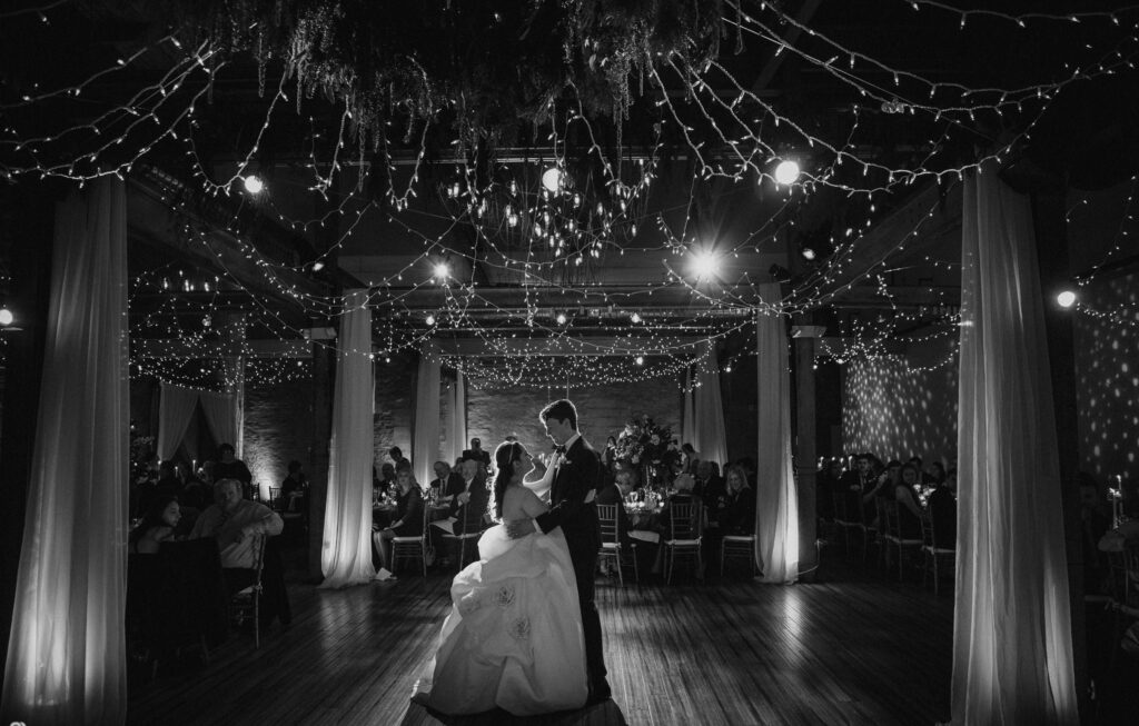 A winter wedding bride and groom's first dance under string lights at Front and Palmer.