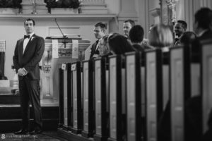 A man in a tuxedo walks down the aisle at Philly's Union League wedding.
