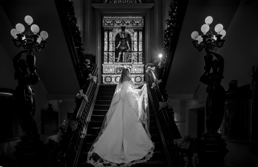 A wedding couple standing on a staircase at Philly's Union League in black and white.