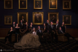 A wedding party posing in front of paintings at Philly's Union League.