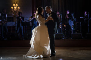 A wedding couple sharing their first dance in front of a band at Philly's Union League.