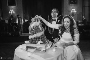 A Philadelphia bride and groom cutting a cake at their Union League wedding.