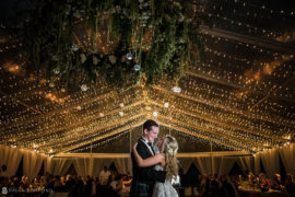 A wedding couple dances in a tent under string lights at the Ocean Club in the Bahamas.