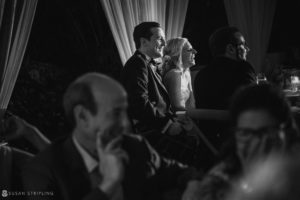 A bride and groom sitting at a table in a dark room, reminiscing about their magical wedding at the Ocean Club in the Bahamas.