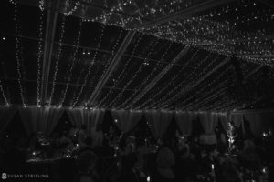 A black and white photo of a wedding reception under string lights at the Ocean Club in the Bahamas.