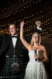 A Wedding couple in kilts holding a microphone at the Ocean Club Bahamas.