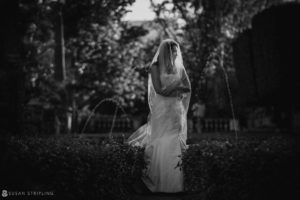 A bride in a wedding dress standing in a Vizcaya garden.
