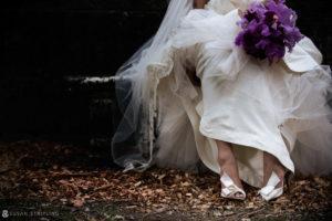 A Vizcaya bride in a white dress with purple flowers on her feet.