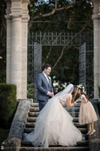 A bride and groom kissing on steps during their Vizcaya wedding ceremony.