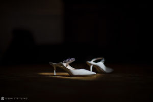 A pair of white wedding shoes on the floor of the Nassau Inn.