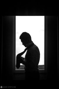 A silhouette of a man looking out of a window at the Nassau Inn.