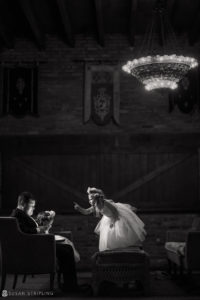 A black and white photo of a bride and groom in a room, captured by a WPPI Grand Master photographer.