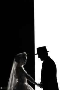 A silhouette of a bride and groom holding hands, captured by a Grand Master photographer at WPPI.