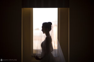 A wedding silhouette of a bride standing in front of a window at Nassau Inn.