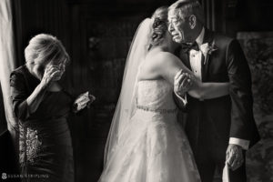 A black and white photo of a bride hugging her father at a Grand Master event.