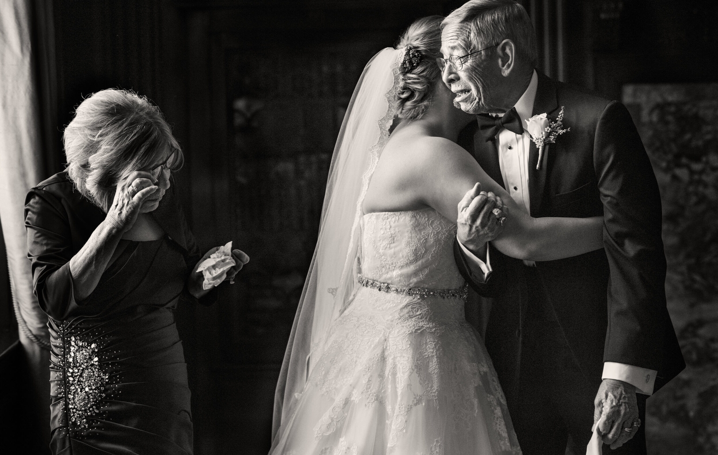 A black and white photo of a bride hugging her father at a Grand Master event.