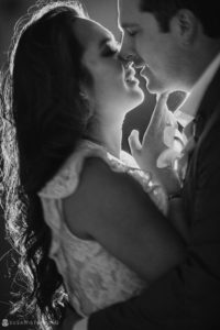 A black and white photo of a bride and groom kissing at their Wedding.