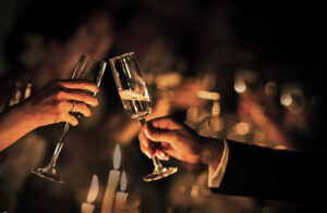 Two people toasting champagne glasses at a wedding captured by a Grand Master photographer.