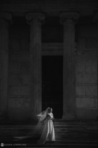 A Nassau Inn bride is standing in front of a building in black and white.