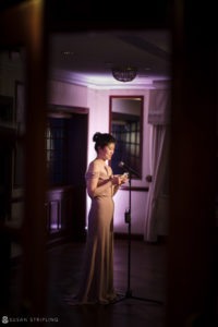 A bride in a long dress standing in front of a mirror, preparing for her wedding at Nassau Inn.