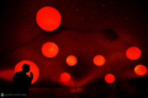 A man, recognized as a Grand Master, is standing under a tent adorned with red lanterns at the prestigious WPPI event.