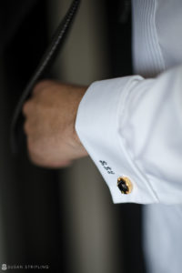 A man's cufflinks with a black and gold design, perfect for a wedding at Loews Hotel Philly.