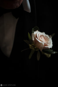 A man in a tuxedo with a flower on his lapel attending a wedding at Florentine Gardens estate.
