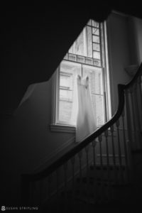 A wedding dress hangs on a stair railing at Loews Hotel in Philly.